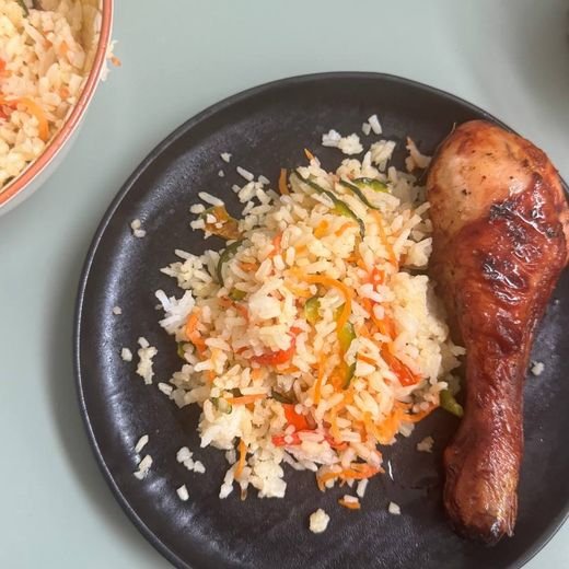 Pollo al horno con arroz con verduras, servido en el plato